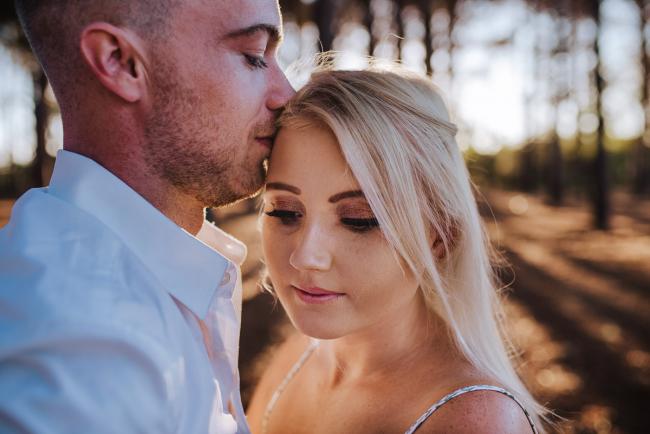 Perth-Couples-Photography-7-of-27 Close up of woman looking down as her partner kisses her head at The Pines Wanneroo during a Golden Hour Perth couples photography session