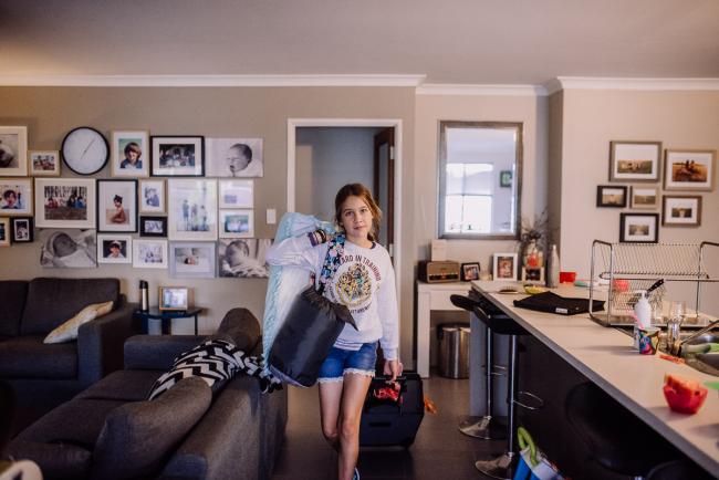 Perth-Family-Photographer-1-of-26 Girl carrying a suitcase in her living area with Perth family photographer
