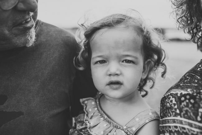 Black and white image of little girl looking at the camera during a Perth extended family photography session