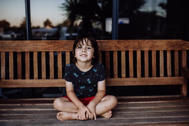 Perth-Family-Photographer-11-of-26 Little boy sitting on a wooden chair with legs crossed with family photographer Perth
