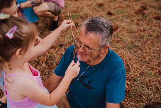 Little girl putting sticks in her grandfather's glasses during a Perth extended family photography session