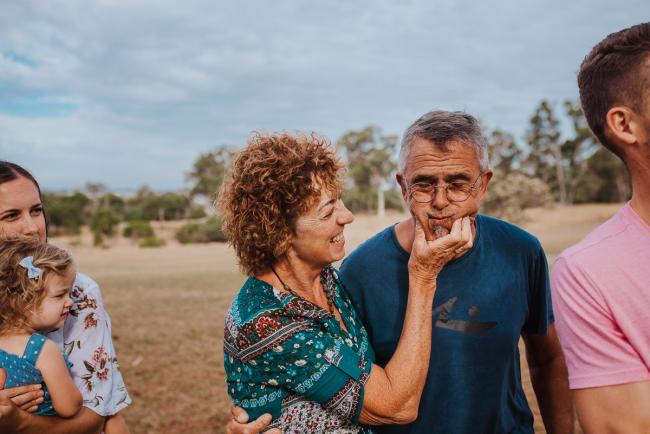 Woman squeezing her husband's cheeks during a Perth extended family photography session