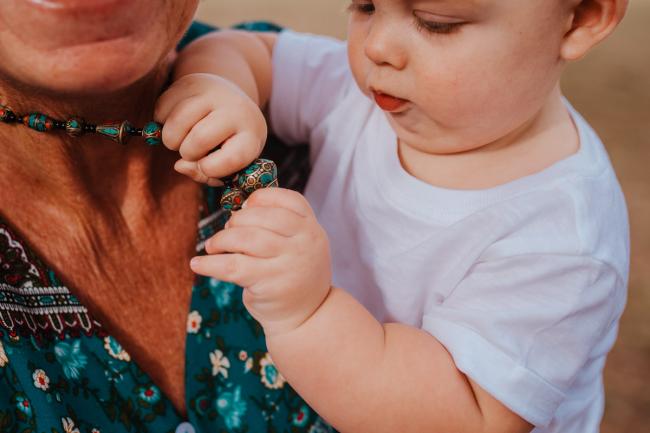 Little boy playing with his grandmother's necklace during a Perth extended family photography session