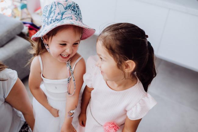 Two little girls smiling at each other during a birthday party captured by Perth events photographer