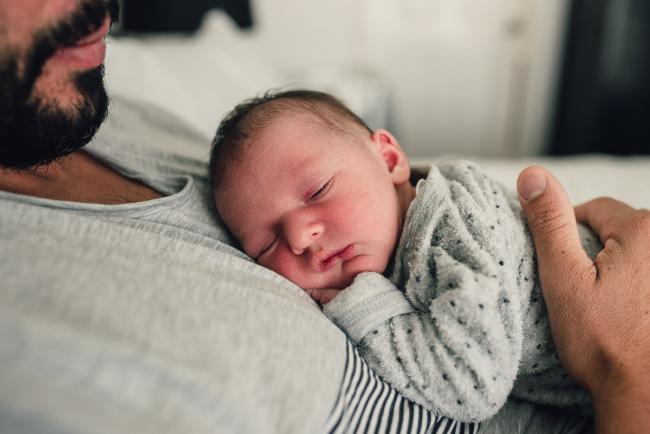 Close of up of new baby sleeping on her dad's chest during a Perth lifestyle newborn photography session