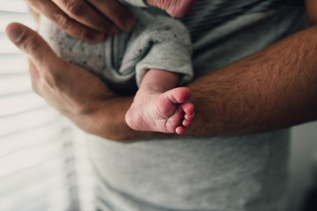 Close up of new baby foot as she's being held by her father during a Perth lifestyle newborn photography session
