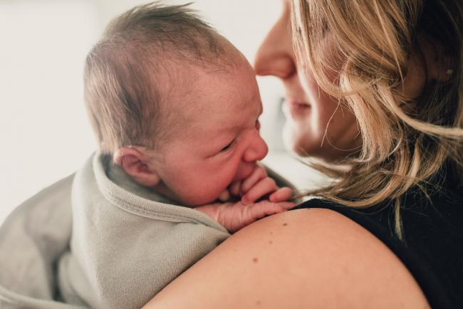 New baby being held on mum's shoulder during a Perth lifestyle newborn photography session