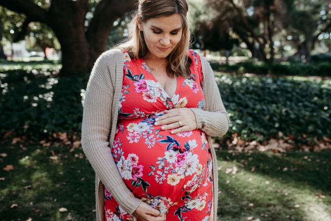 Pregnant woman holding her tummy during a Perth maternity session at Hyde Park