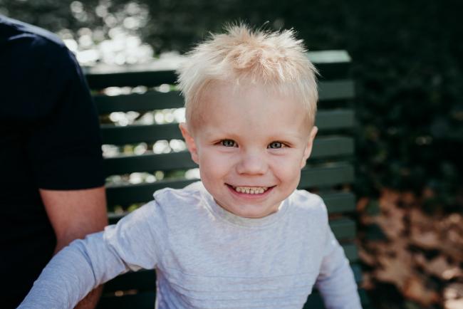 Little boy smiling at the camera during a Perth maternity session at Hyde Park