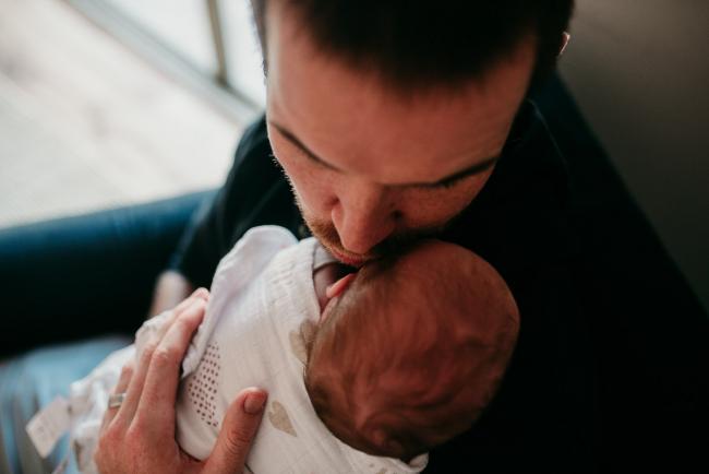 Newborn-Photographer-Perth-29-of-37 Father holding and kissing his newborn baby during a Perth newborn lifestyle session