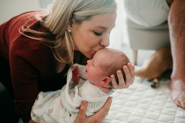 Newborn-Photographer-Perth-37-of-37 Mother lifting and kissing her newborn baby during a Perth newborn lifestyle session