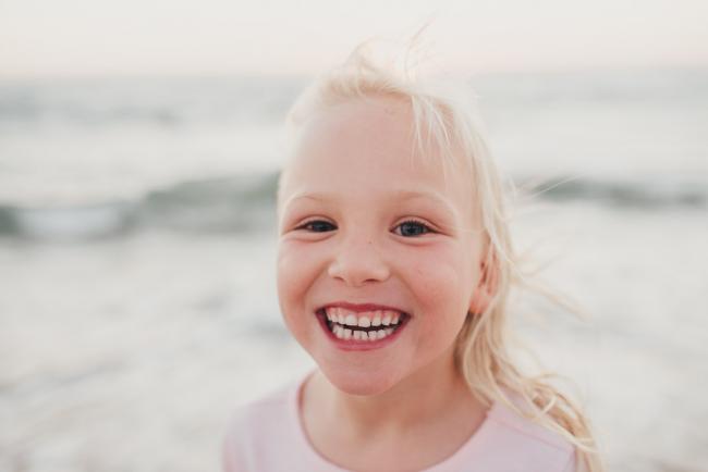Little girl smiling at the camera at Burns Beach during a Perth family photography session