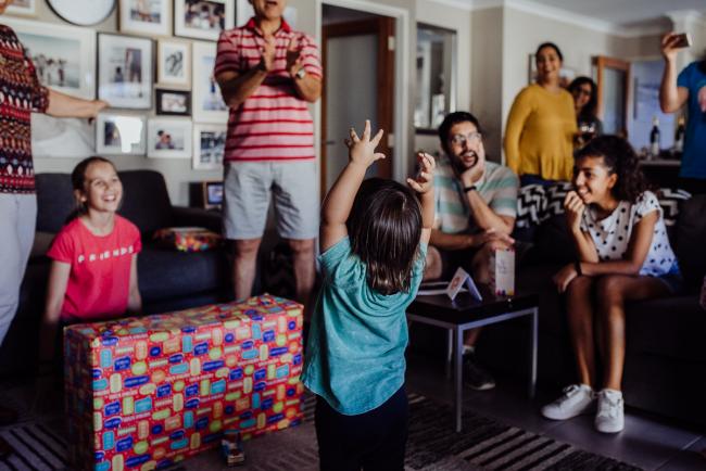 20190406-DSC_9958 Little boy standing in the middle of the room with his arms in the air, surrounded by people smiling with Perth lifestyle family photographer