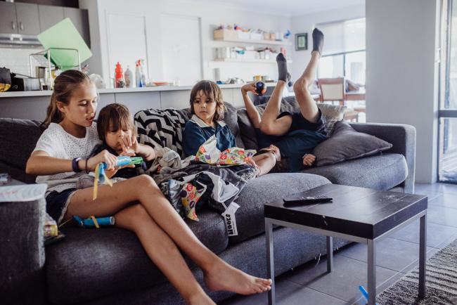 20190412-DSC_1659 Kids on the couch with two opening presents, one looking on, and one upside down with Perth lifestyle family photographer