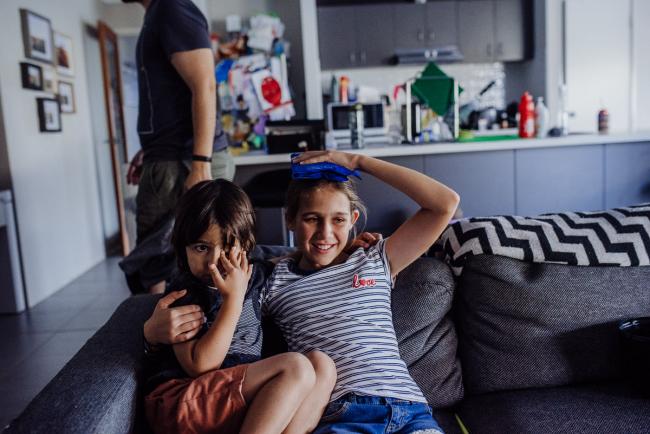 20190413-DSC_1686 Girl with an ice pack on her head as she sits on the couch and her little brother sits next to her with Perth family lifestyle photographer