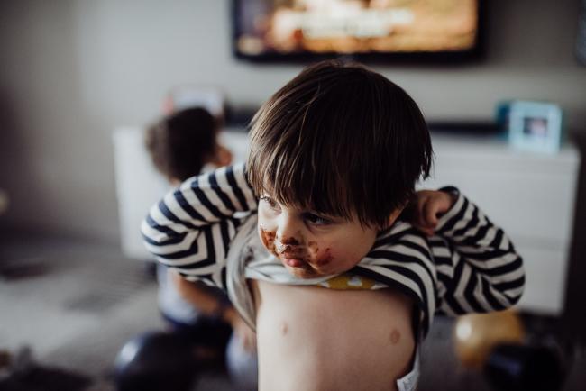 20190420-DSC_1778 Little boy with a chocolate covered face lifting up his top with family photographer Perth