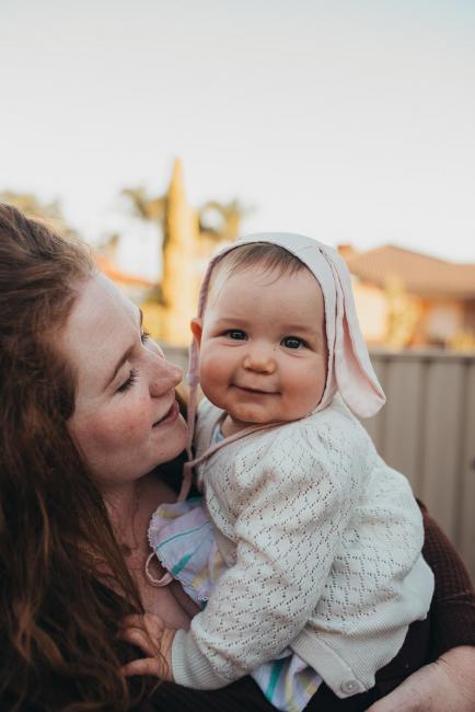 20190422-DSC_2929 Mother holding her baby girl who is smiling at the camera with Perth family photographer