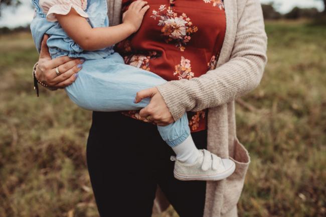 Mother holding her daughter's legs which are wrapped around her with Perth family photographer at Perry's Paddock