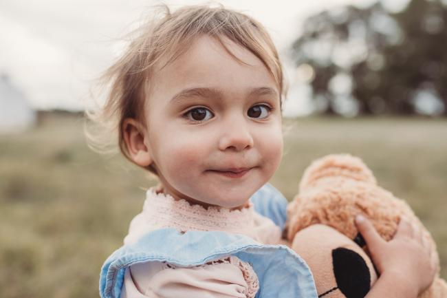 Little girl looking at the camera with Perth family photographer at Perry's Paddock