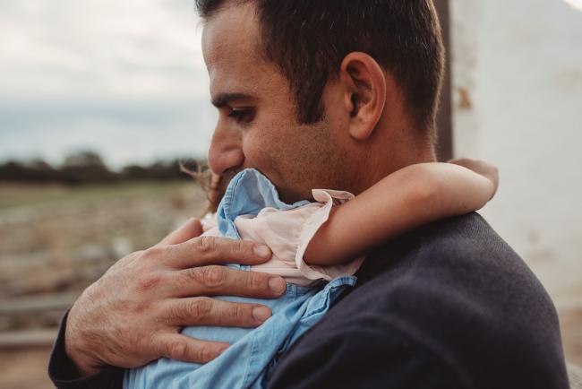 Little girl with her arms wrapped around her father with Perth family photographer at Perry's Paddock