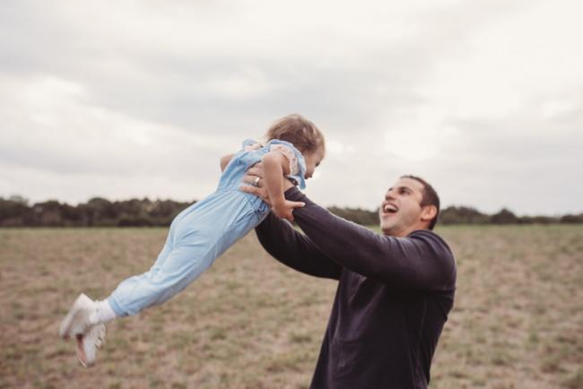 Father flying his daughter in the air with Perth family photographer at Perry's Paddock