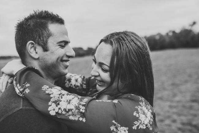 Black and white image of couple laughing as they embrace with Perth family photographer at Perry's Paddock