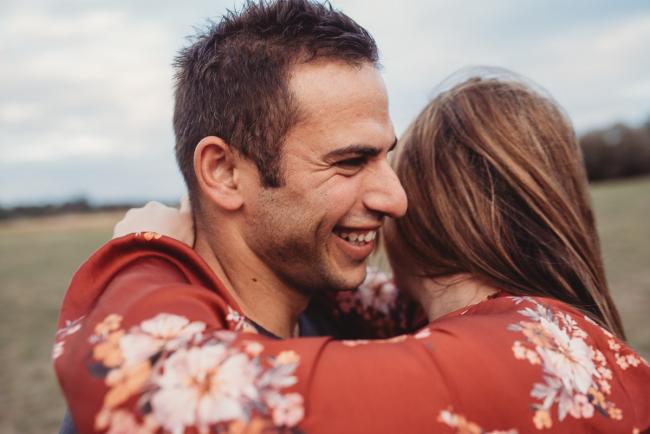 Man laughing as he embraces wife with Perth family photographer at Perry's Paddock