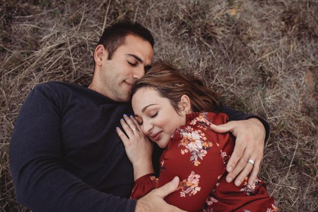 Husband and wife laying on the grass with Perth family photographer at Perry's Paddock