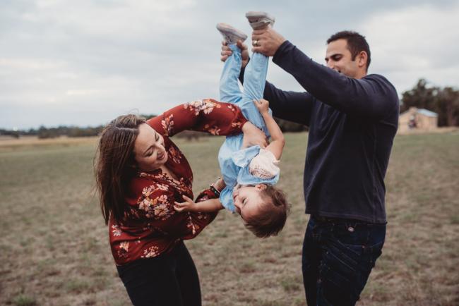 Parents lifting their daughter upside down with Perth family photographer at Perry's Paddock