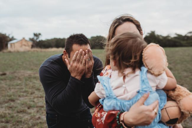 Father playing peekaboo with Perth family photographer at Perry's Paddock
