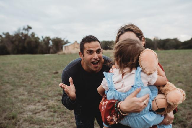 Father playing peekaboo with Perth family photographer at Perry's Paddock