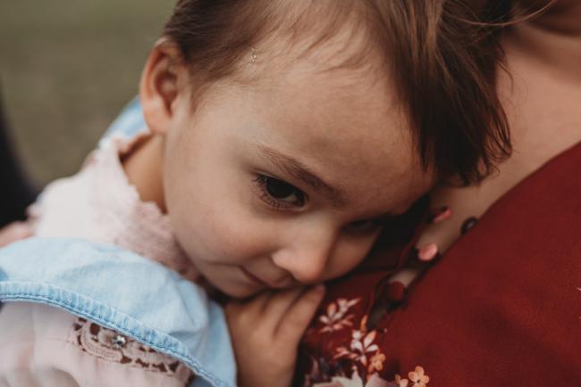 Close up of little girl cuddled in to her mother with Perth family photographer at Perry's Paddock