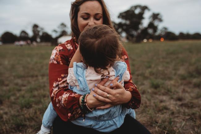 mother holding onto her daughter who sits on her lap with Perth family photographer at Perry's Paddock