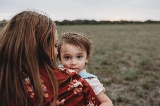 lttle girl looking over her mother's shoulder with Perth family photographer at Perry's Paddock
