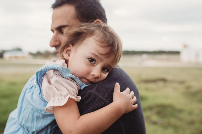 Little girl cuddling her father with Perth family photographer at Perry's Paddock