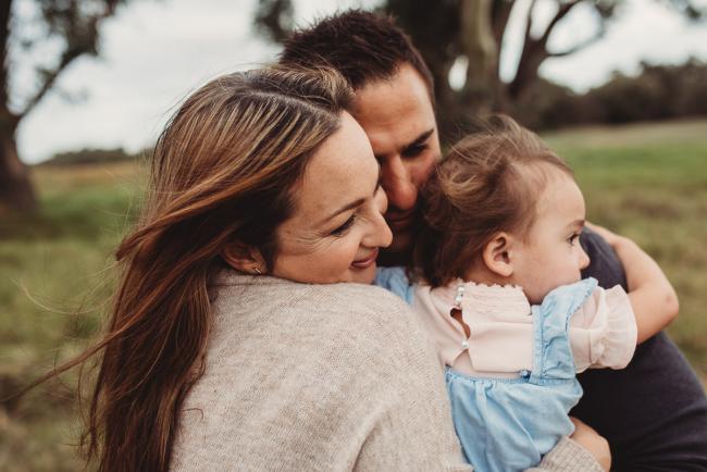 Family of 3 cuddling together with Perth family photographer at Perry's Paddock