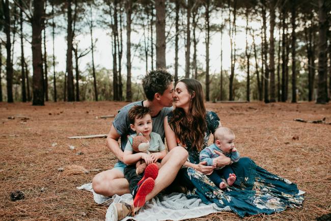 Family of four sitting on a rug during a Perth family photography session at the Pines Wanneroo
