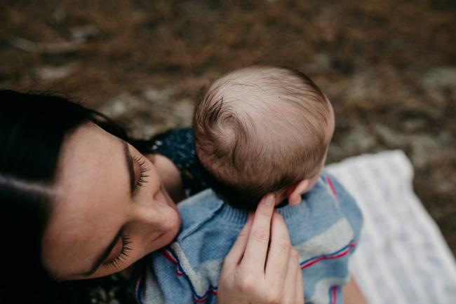 Family-Photographer-Perth-The-Pines-10-of-21 Top down image of a mother touching her baby's head during a Family photographer session at The Pines in Wanneroo