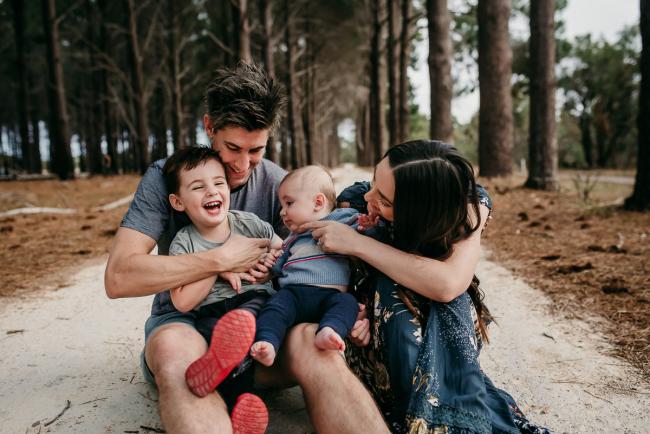 Family-Photographer-Perth-The-Pines-13-of-21 Family sitting together with the little boy laughing during a Family photographer session at The Pines in Wanneroo