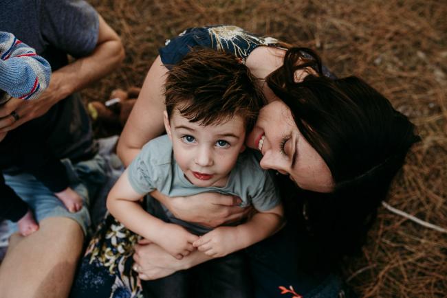 Family-Photographer-Perth-The-Pines-4-of-21 Mother hugging her little boy as he looks up at the camera during a Family photographer session at The Pines in Wanneroo