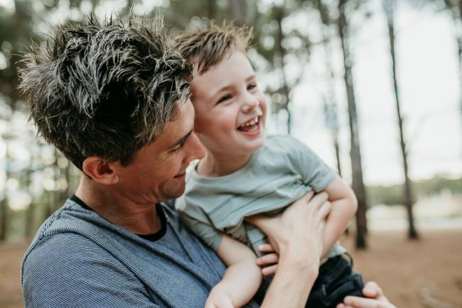 Family-Photographer-Perth-The-Pines-7-of-21 Father tickling his son who is laughing during a Family photographer session at The Pines in Wanneroo
