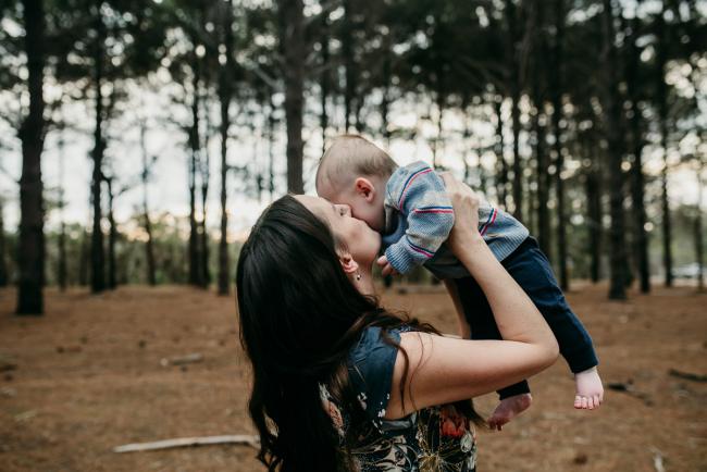 Family-Photographer-Perth-The-Pines-8-of-21 Mother lifting up her baby and kissing him during a Family photographer session at The Pines in Wanneroo