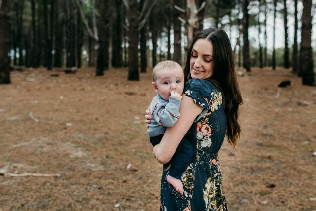 Family-Photographer-Perth-The-Pines-9-of-21 Mother holding her little baby on her hip during a Family photographer session at The Pines in Wanneroo