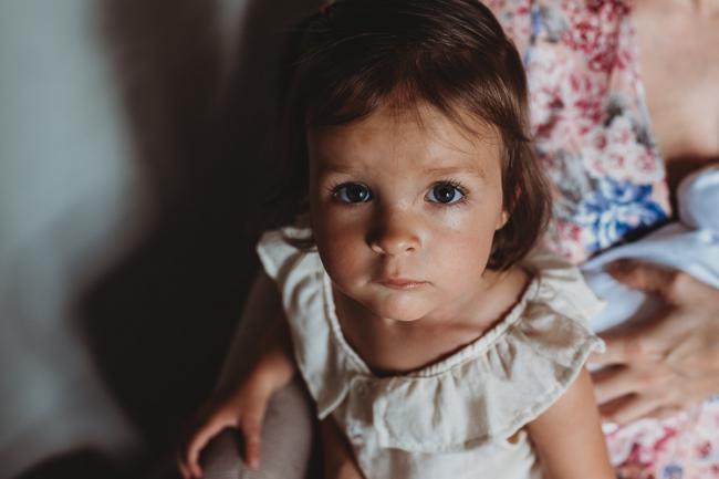 Little girl looking up at the camera with Perth lifestyle family photographer