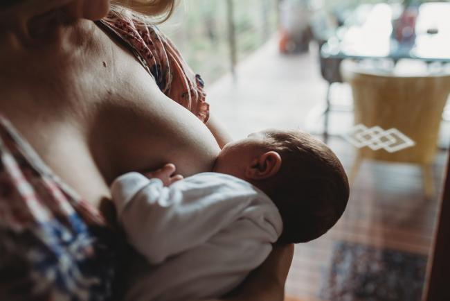 New baby breastfeeding during an in-home Perth newborn lifestyle session