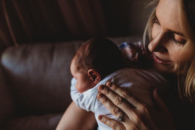 Mother's hand on her new baby's back during an in-home Perth newborn lifestyle session