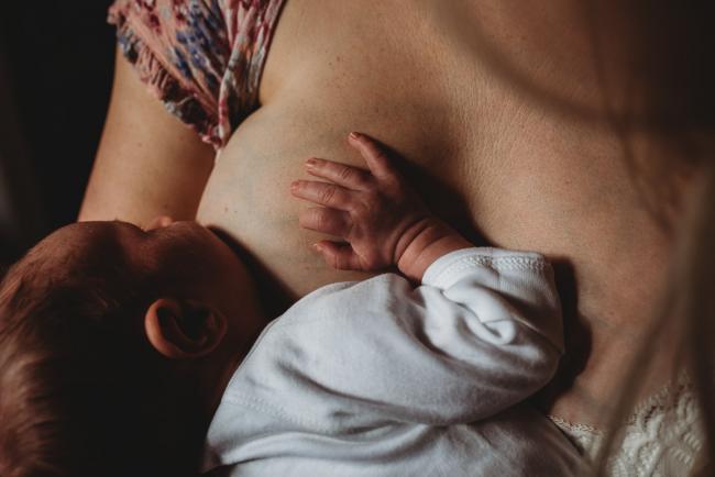 Baby breastfeeding during an in-home Perth newborn lifestyle session