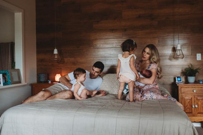 Family of 5 on a bed during an in-home Perth newborn lifestyle session