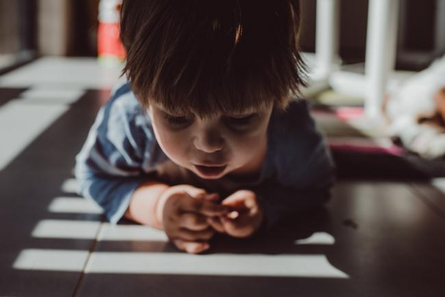 Little boy lying on the floor in shadows with Perth lifestyle photographer