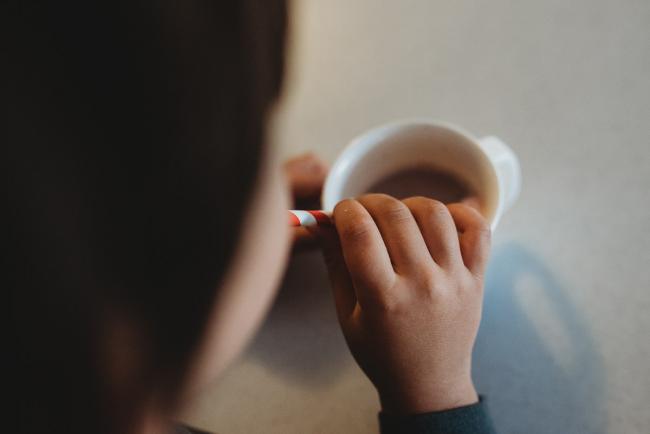 Top down image of boy drinking hot chocolate through a straw with Perth family photographer